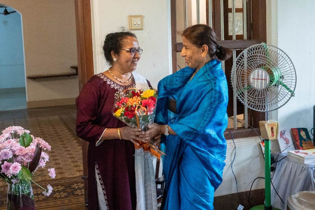 Two women holding flowers and standing in a room

AI-generated content may be incorrect.